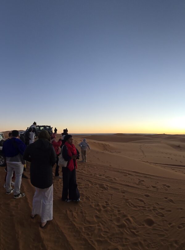 Sunrise over the Merzouga Sahara with 4x4 vehicles