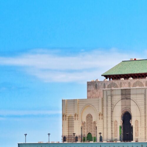 The Hassan II Mosque in Casablanca seen from the Atlantic seafront, its minaret rising above the ocean wall