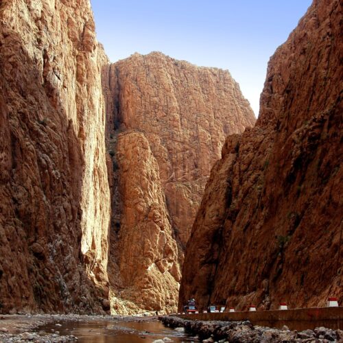 The sheer limestone walls of the Todra Gorge near Tinghir with a shallow stream running along the canyon floor