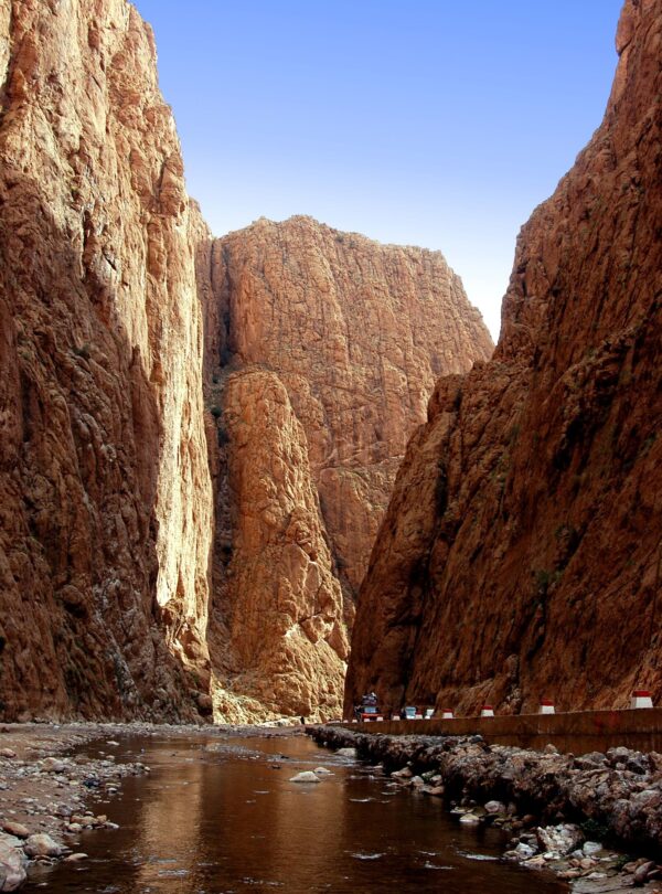 The sheer limestone walls of the Todra Gorge near Tinghir with a shallow stream running along the canyon floor